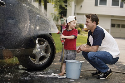 image of father and son washing car